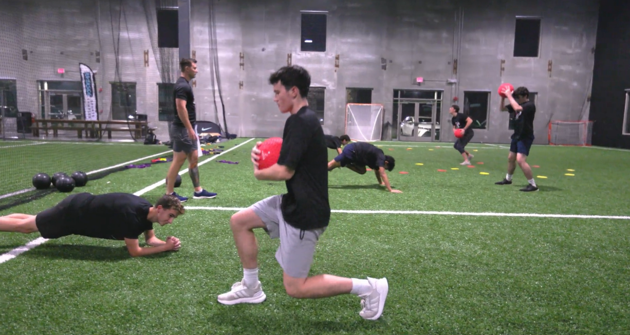 Francis Mulkern supervising strength exercises on the indoor turf